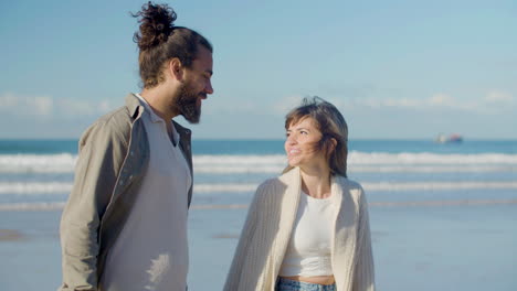 beautiful caucasian couple strolling along seashore