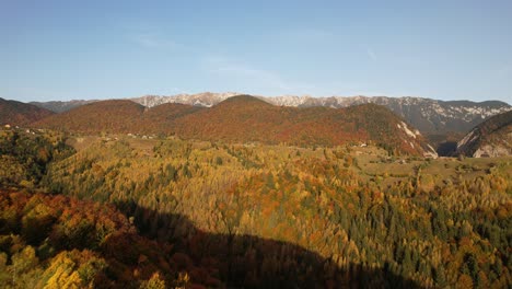 Pueblo-De-Magura-En-Otoño-Con-Vibrante-Follaje-De-Otoño-Y-Montañas,-Vista-Aérea