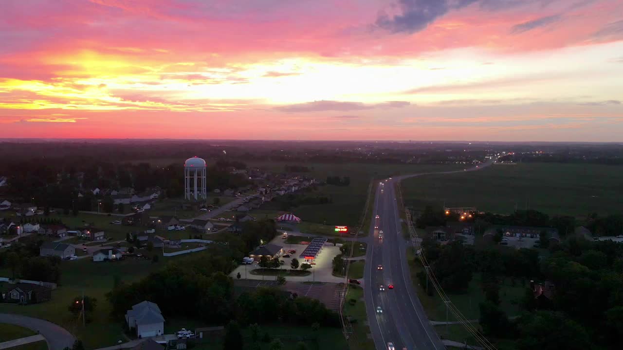 Aerial hyperlapse of suburbs and street traffic during a colorful sunrise