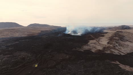 Volcán-Activo-Humeante-En-Paisaje-Volcánico-De-Roca-Negra-En-Islandia