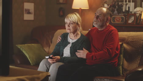 elderly couple watching tv at home