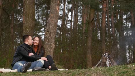 romantic couple by a bonfire in the forest