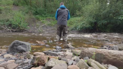 Statische-Aufnahme-Eines-Fischers-Beim-Fliegenfischen,-Der-Versucht,-Fische-In-Schnell-Fließendem-Wasser-Zu-Fangen