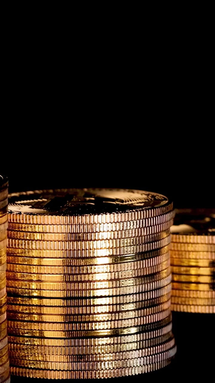 Gold digital coins rotate in stacks, dramatic lighting, black background, smooth camera movement, macro view