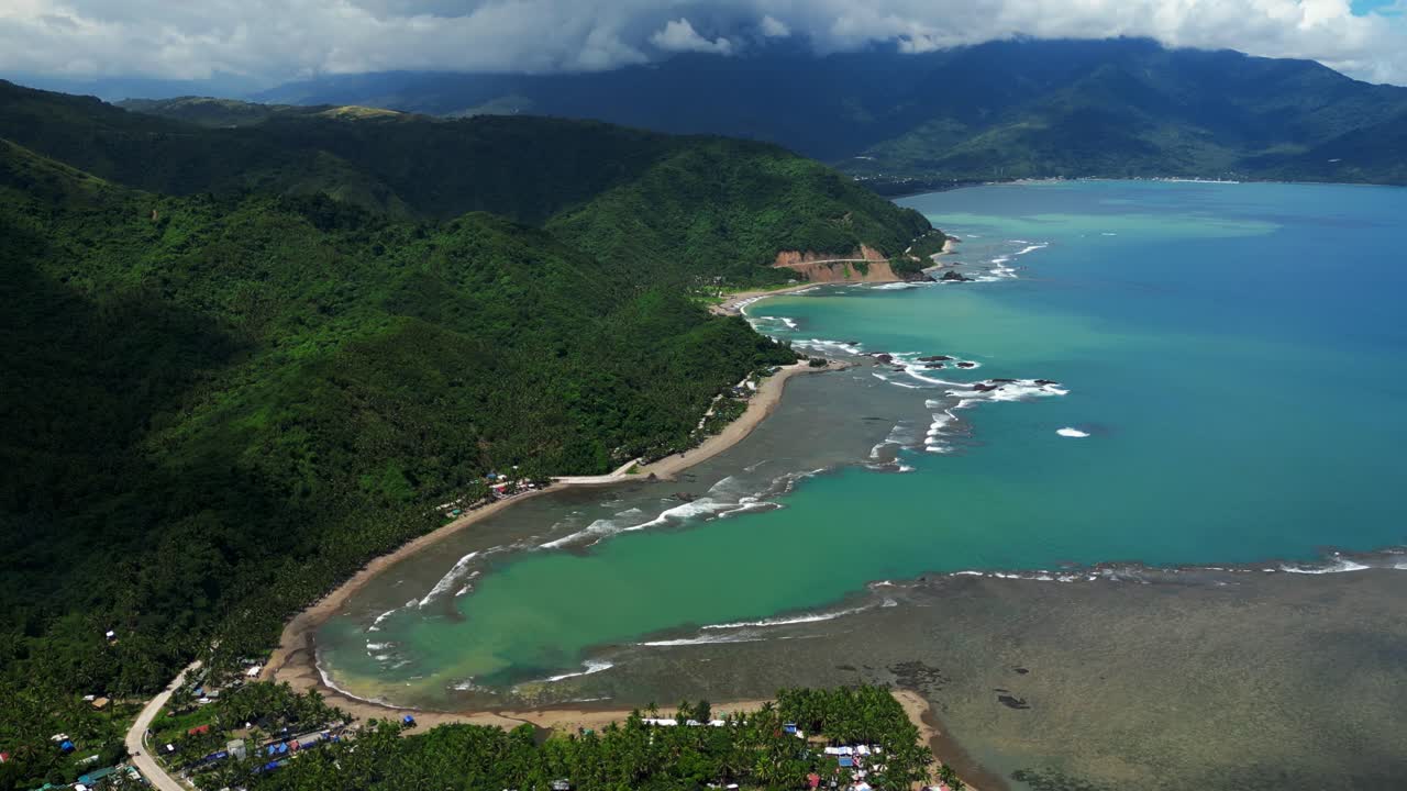 Side pan aerial bird’s‑eye view of Dingalan, Aurora, slowly zooming to reveal turquoise waters, curved shoreline, and lush green mountains blending with the coastal town