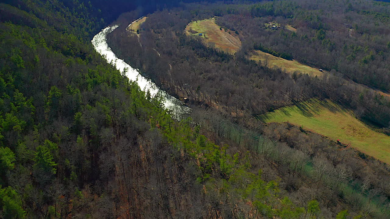Aerial Shot Over Mountain Ridge Towards River and Valley