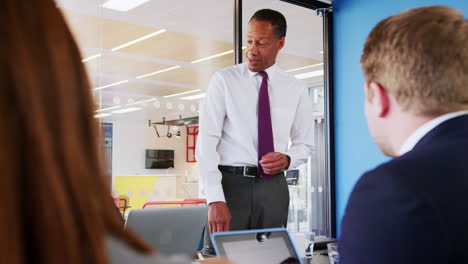 black male manager talking at a business meeting, close up