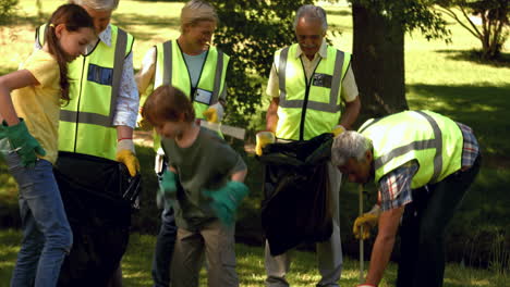 active family collecting rubbish in park