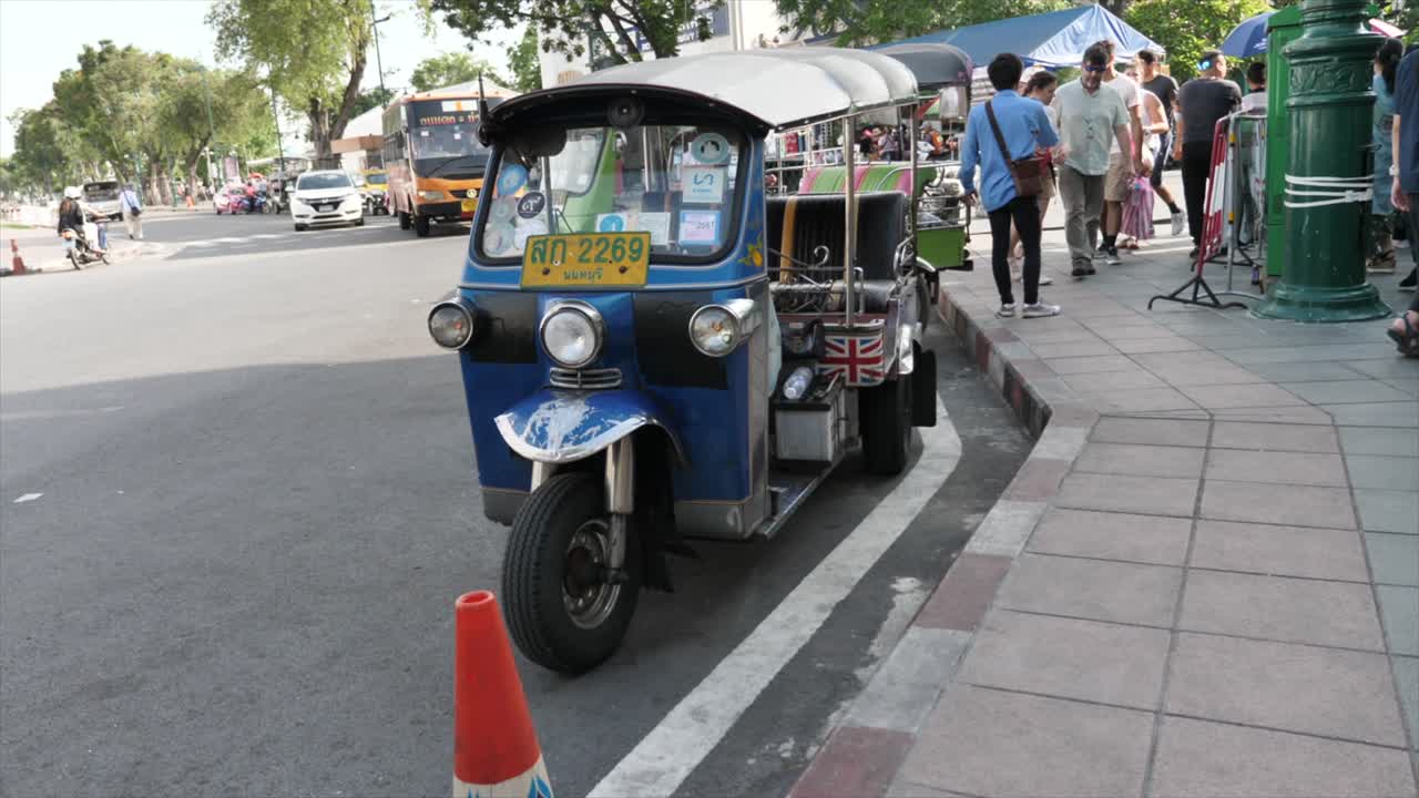 Tuk-tuk Ricksaw motorbikes parked along the street in Bangkok