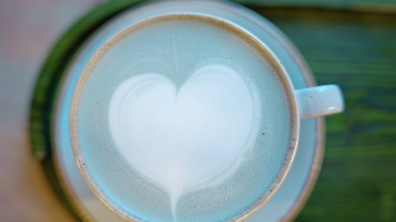 Top down shot of foam latte art on blue matcha drink