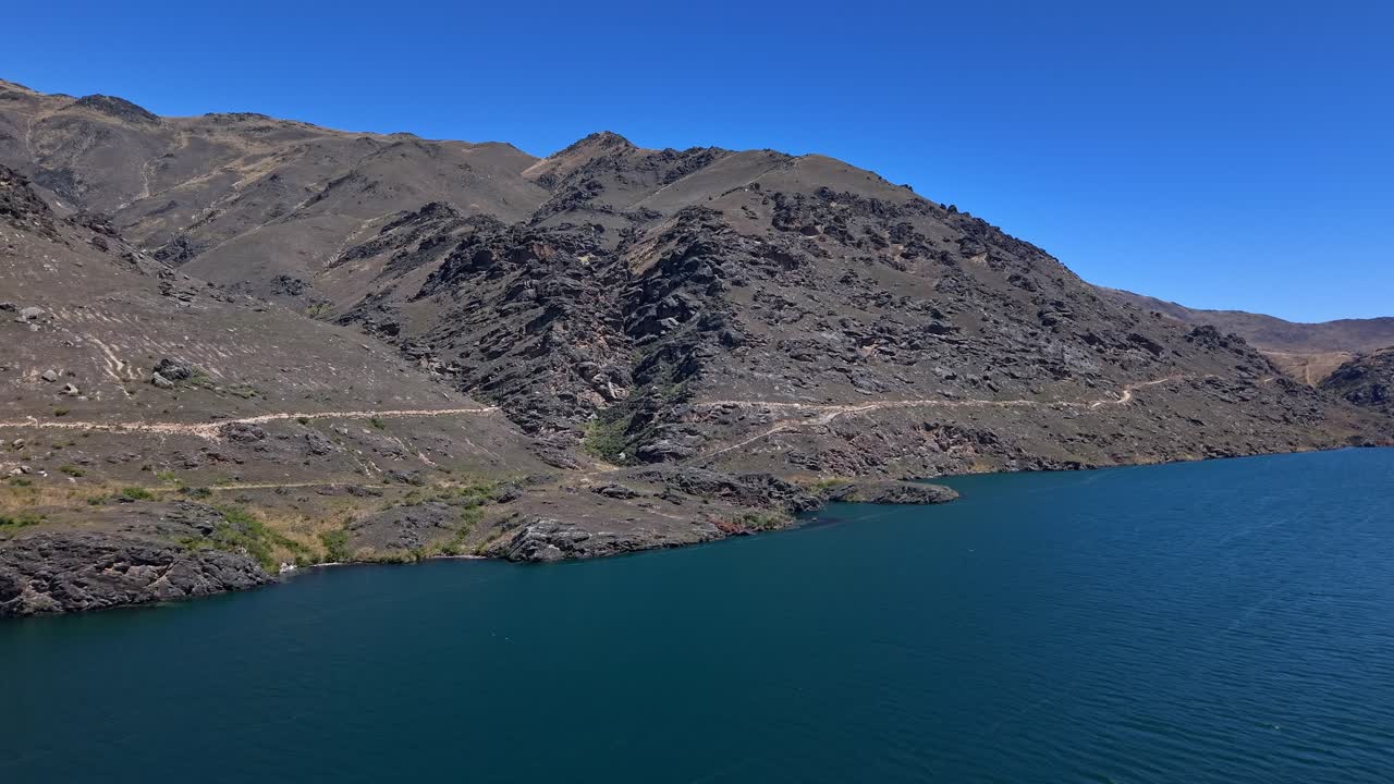Scenic view of Clutha River and rocky hills, Lake Dunstan Trail, sunny day