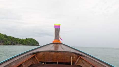 boat travels through ocean towards lush island