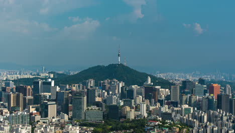 iconic city view of seoul, time lapse of seoul cityscape featuring namsan tower and blue sky with fluffy fast moving clouds - panning motion