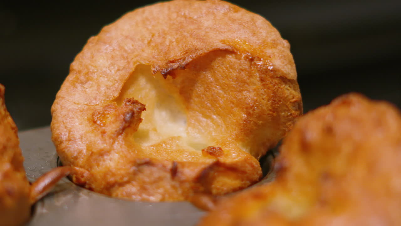 Primer plano de pudín Yorkshire británico recién cocinado y bien elevado. Perfecto para anuncios de comida de alta gama, promociones de asado dominical británico y encabezados de recetas apetitosas