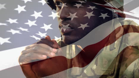 african american soldier looking forward with us flag waving foreground