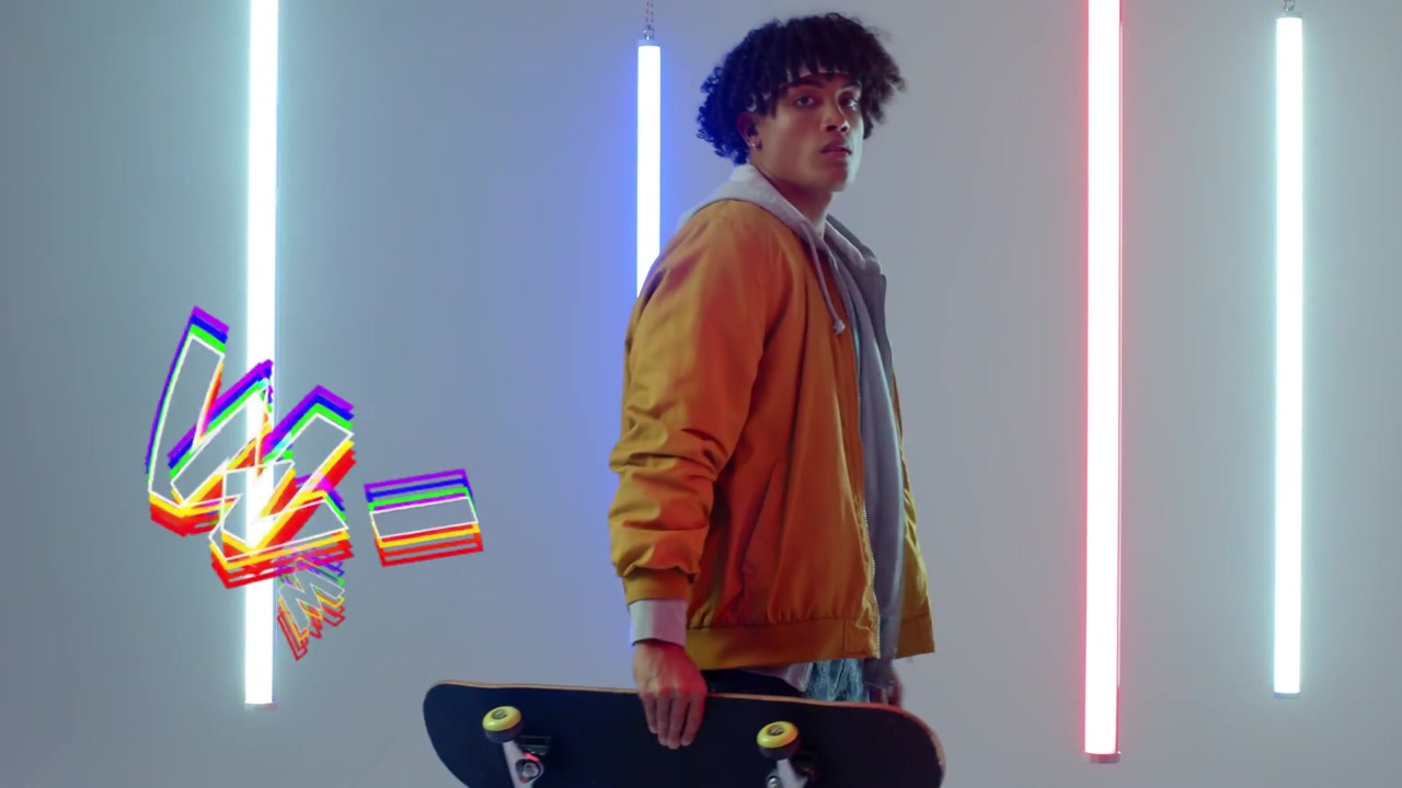 Vertical video: Balancing skater in yellow jacket lifting board, posing in neon studio with WINNING
