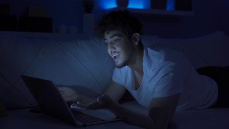 seeing his failure on the laptop, the young man gets angry.