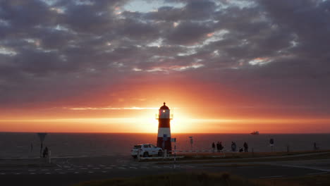 the lighthouse of westkapelle during a bright orange sunset, with a lot of wind