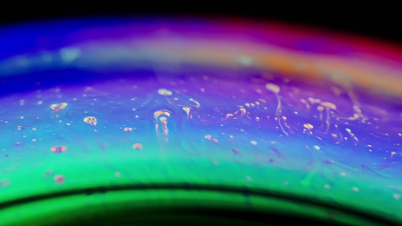 Vibrant macro shot of swirling iridescent soap film with colorful abstract textures