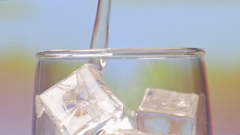 pouring water with ice into a glass