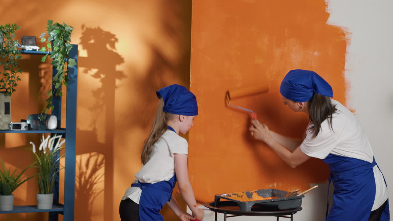 Mother and Daughter Painting Wall Orange Together