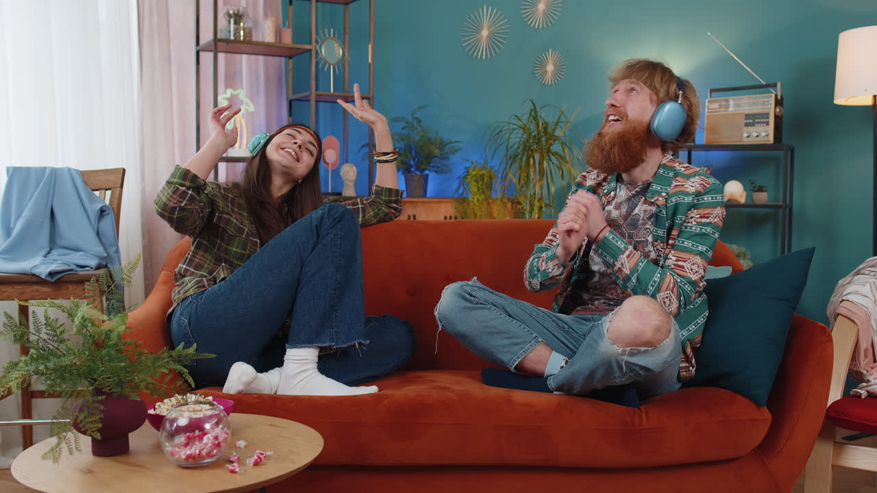 가족 남자 여자 무선 헤드폰 춤추고 집 소파에서 좋아하는 록 앤 롤 음악을 듣고