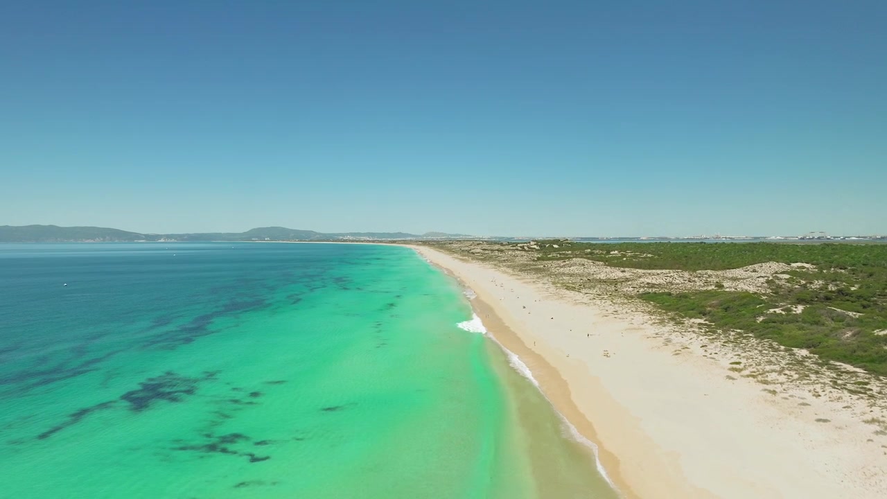 Arenas doradas y aguas turquesas desde una perspectiva de dron ascendente.