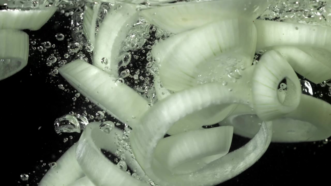 Sliced White Onions Falling into Water in Slow Motion