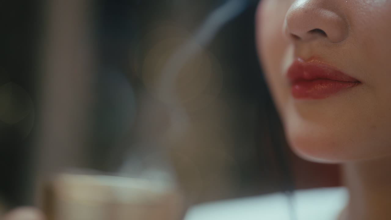 뜨거운 음료 를 마시는 여자