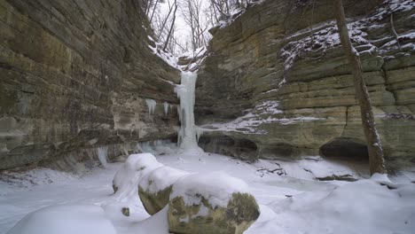 frozen waterfall in rocky valley on beautiful snowy winter day