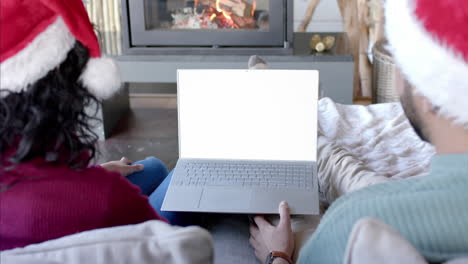 happy diverse couple having christmas laptop video call with copy space screen, slow motion