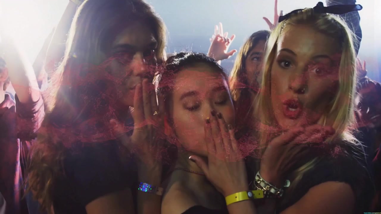 Three friends reacting to crowd energy placing hands on lips and blowing kisses with music flares