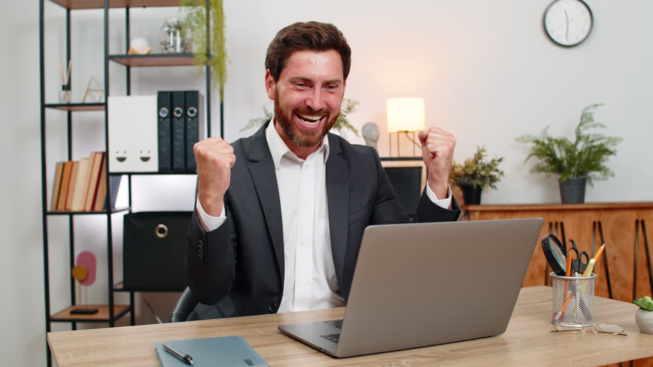 Middleaged businessman celebrates profit green chart on laptop shouts hooray after online game win