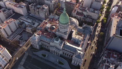 Aerial-birds-eye-view-of-National-Congress-in-Buenos-Aires-and-driving-cars-on-road-during-sunset---Beautiful-historic-cupola-of-Palace-of-the-Argentine
