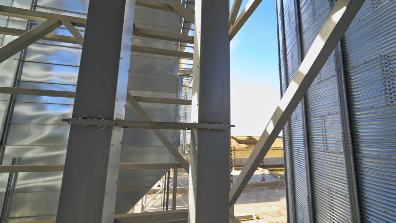 Modern warehouse. Metal frame on industrial plant. Grain elevator. Storage tanks with metal equipment outdoors.