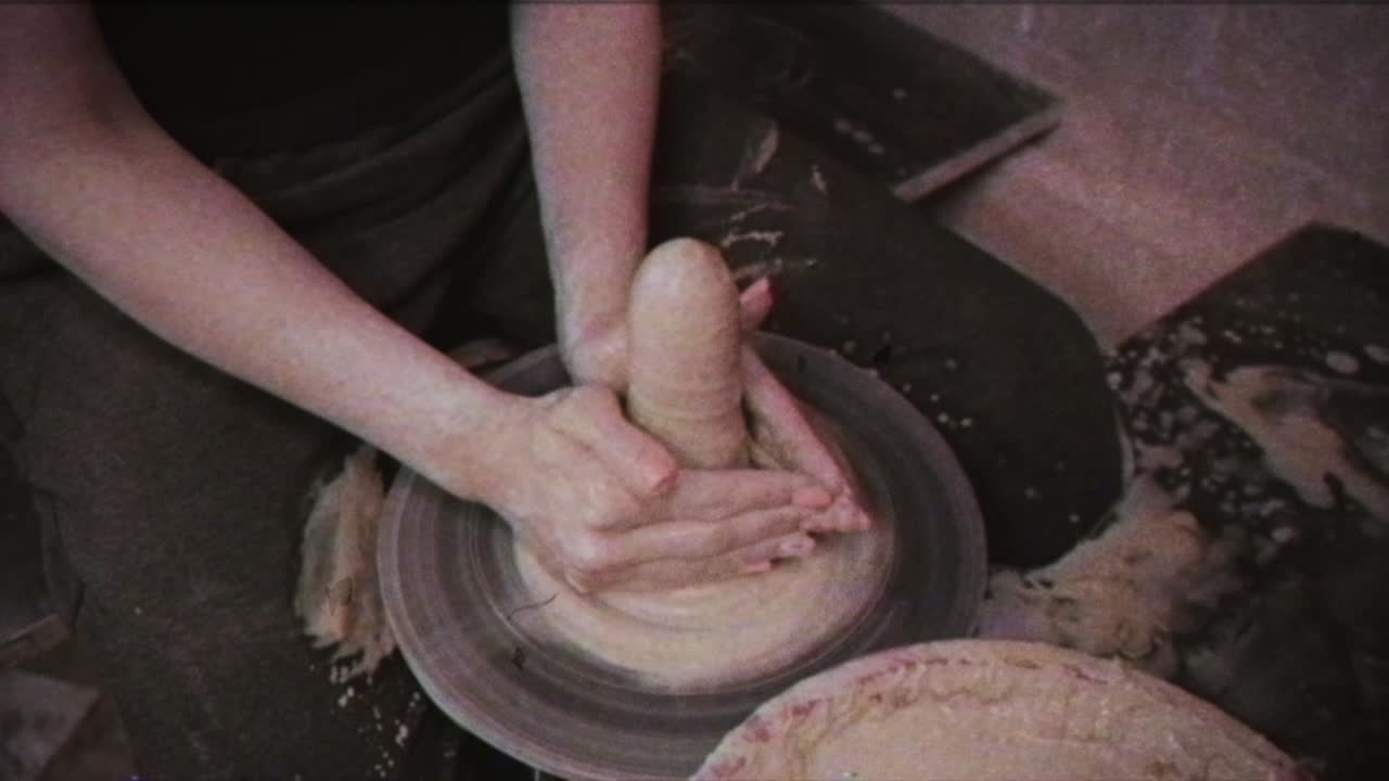 un alfarero enseña a una mujer a hacer platos de arcilla. un hombre toma las manos de una mujer. efecto vintage.
