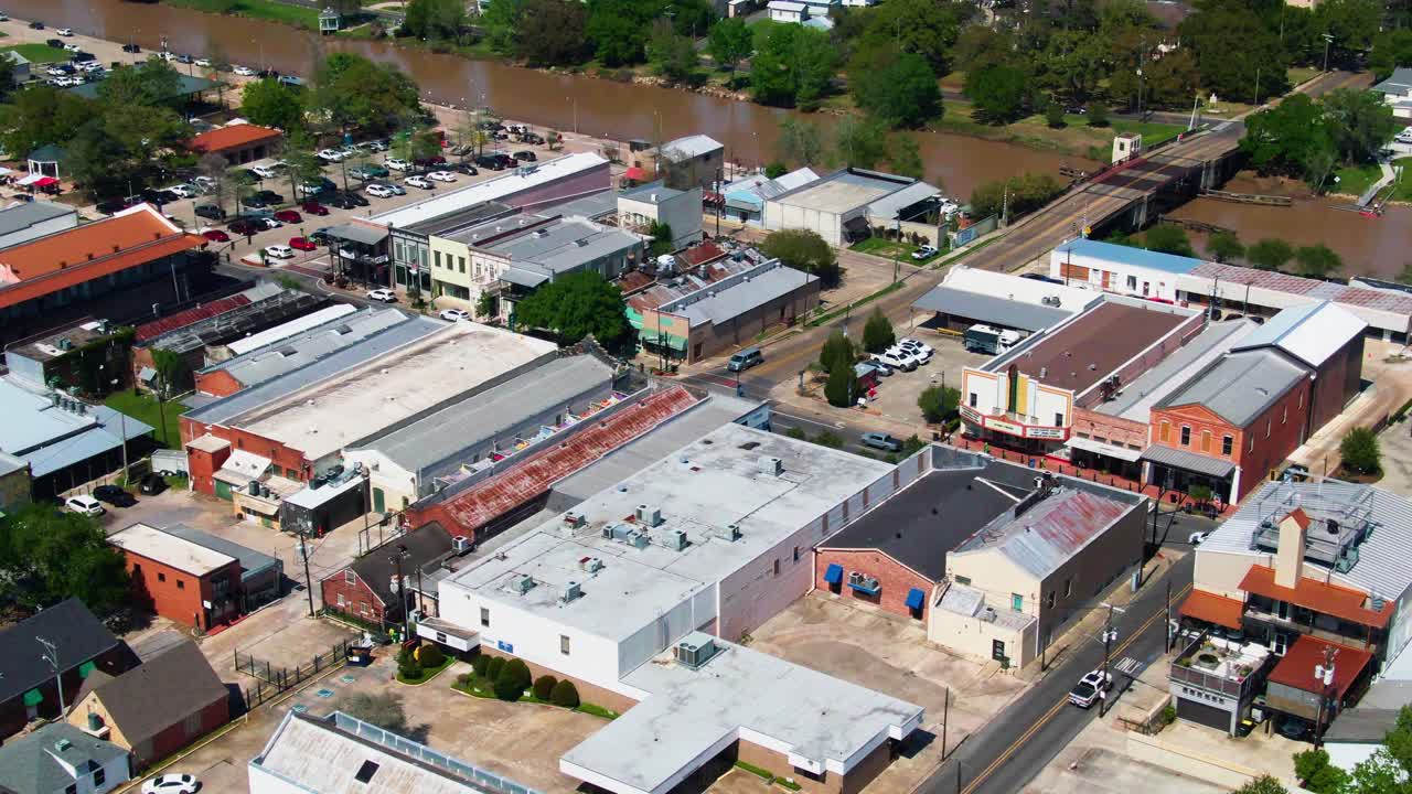 Drone shot over downtown New Iberia, Louisiana, showing Duperier Bridge, Bayou Teche, and nearby retail businesses along E Main Street