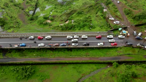 Ciudad-De-Lonavla-Estación-De-La-Colina-Disparo-De-Dron-Después-De-La-Vista-Superior-Del-Automóvil-Vista-De-Pájaro-En-Un-Día-Lluvioso-Ciudad-Inova-Pasando-A-Través-Del-Tráfico-Fuera-De-La-Carretera-Ciudad-De-La-Presa-De-Bhushi