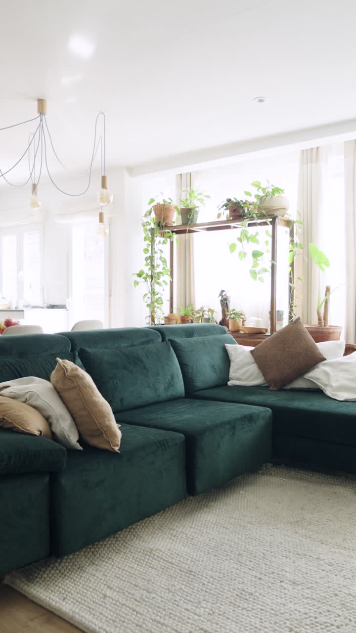 Modern Living Room Interior with Green Sofa and Abundant Houseplants