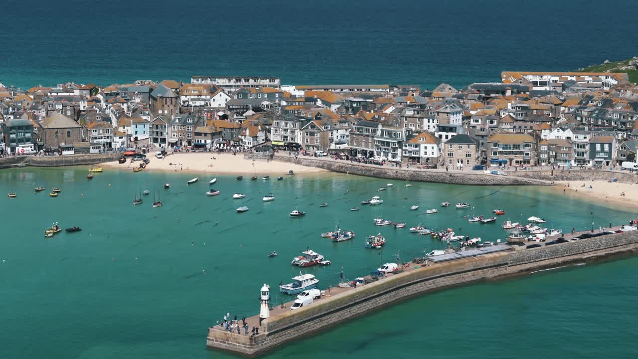 Descending drone pan up over vivid St Ives bay with deep blue ocean beyond