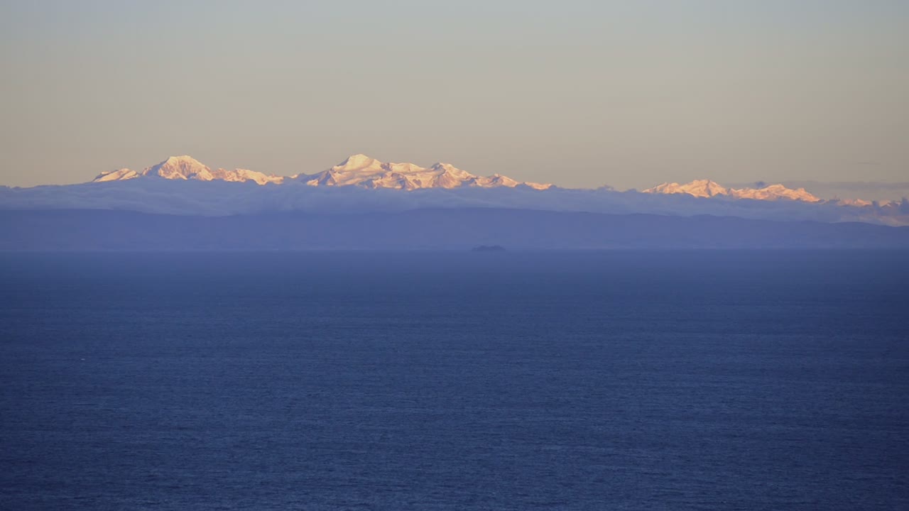 Landscape view of Lake Titicaca, Peru, with mountains in the background, at dusk