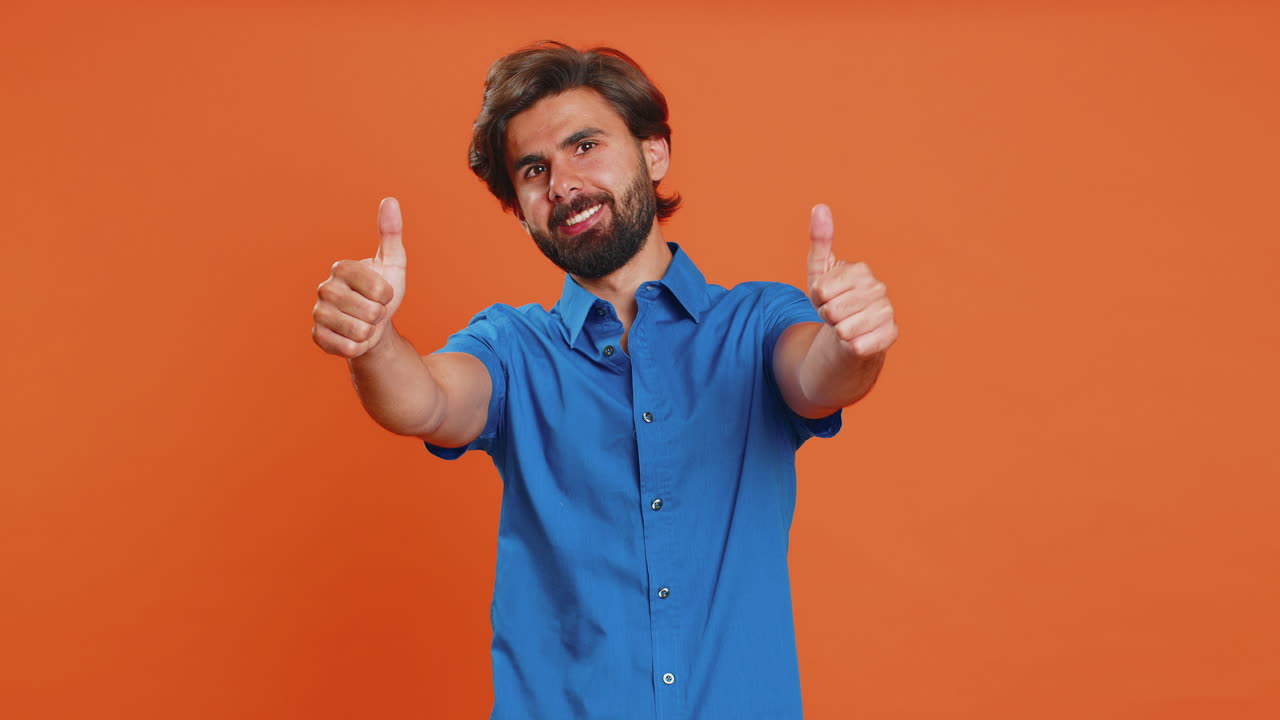 Young man raises thumbs up agrees or gives positive reply recommends advertisement likes good idea