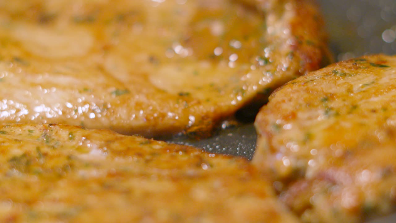 Slow Motion Close Up of Chinese Chicken Steak Fillets in Bubbling Oil in Hot Frying Pan Being Cooked. Food Photography Footage 4K.