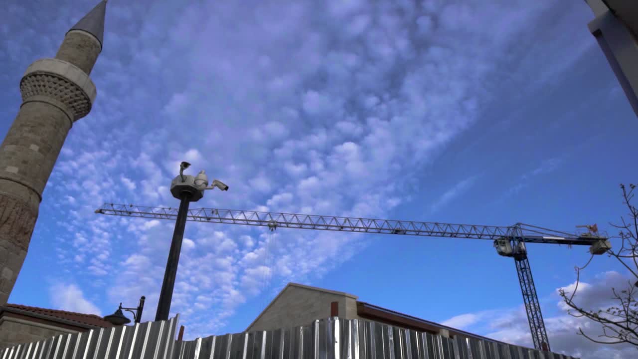 4K time-lapse video of construction crane working while restoration of old mosque