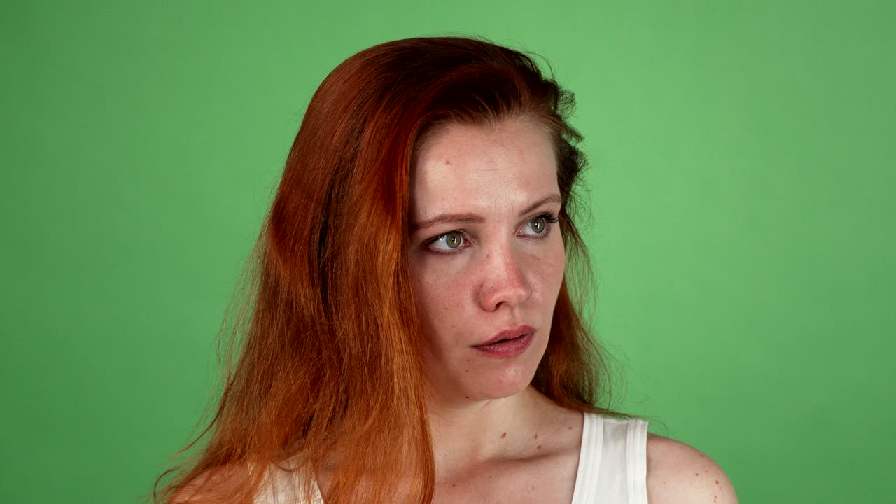 Donna arrabbiata dai capelli rossi su sfondo chroma key verde