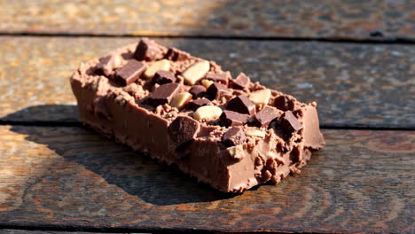 delicious chocolate bar with nuts on a wooden surface