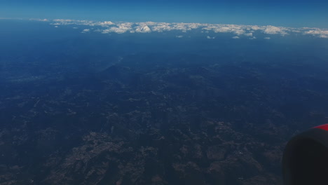 aerial view of mountains and clouds from airplane window