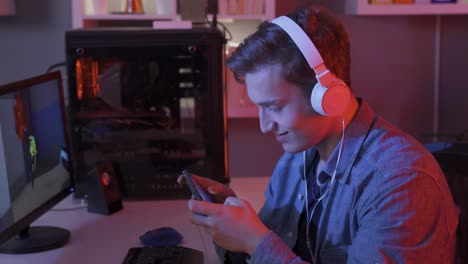 young man live streaming and playing mobile game on smartphone at home.