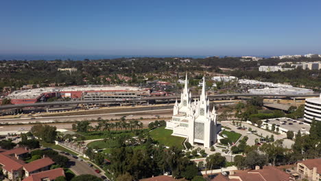 San-Diego-Mormon-Temple-Near-La-Jolla-With-Structures-And-Highways-In-Background-During-Daytime---Aerial,-Arc-Shot