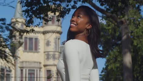 Con-El-Castillo-De-Stollmeyer-Al-Fondo,-Una-Joven-Con-Un-Traje-Blanco-Disfruta-De-Su-Día-En-La-Ciudad.